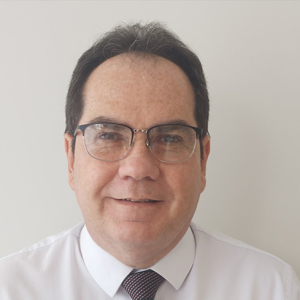 Homem de óculos sorrindo com camisa social branca